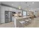 Modern kitchen with stainless steel appliances, white cabinets, and a large center island with seating at 13841 Campoleone St, Venice, FL 34293