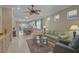 Cozy living room with neutral walls, tile flooring, a ceiling fan, and a view into the dining area at 13841 Campoleone St, Venice, FL 34293