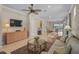 Bright living room with tile floors and a view into the open-concept dining and kitchen area at 13841 Campoleone St, Venice, FL 34293