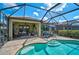 Beautiful pool and lanai area with ample seating and views of the lake and lush landscaping for relaxing outdoors at 13841 Campoleone St, Venice, FL 34293