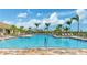 Community swimming pool with ample lounge chairs surrounded by palm trees and landscaping at 13841 Campoleone St, Venice, FL 34293