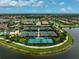 Aerial view of community tennis and pickleball courts next to a lake and luxury homes at 13841 Campoleone St, Venice, FL 34293