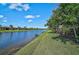 Serene water view along a picturesque canal with lush greenery, creating a peaceful backyard setting at 13841 Campoleone St, Venice, FL 34293
