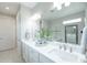 Stylish bathroom features double vanity, large mirror, quartz countertops, and glass-enclosed shower at 13871 Miranese St, Venice, FL 34293
