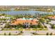 Aerial view of a community pool and clubhouse surrounded by palm trees and water features at 13871 Miranese St, Venice, FL 34293