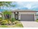 Charming single Gathering home showcasing a paved driveway and lush, well-maintained landscaping at 13871 Miranese St, Venice, FL 34293