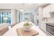 Bright kitchen showcases white cabinets, island, stainless steel appliances, and flows into the dining area at 13871 Miranese St, Venice, FL 34293