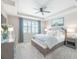 Serene main bedroom features tray ceiling, ceiling fan, light-colored walls, bench and soft, patterned bedding at 13871 Miranese St, Venice, FL 34293