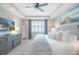 Comfortable main bedroom features tray ceiling, ceiling fan, light-colored walls, and soft, patterned bedding at 13871 Miranese St, Venice, FL 34293