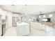 Spacious open-concept layout with kitchen island, stainless steel appliances, dining area and comfortable living room at 13871 Miranese St, Venice, FL 34293