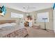 Cozy bedroom featuring a plush bed, a vanity area, and natural lighting from the windows at 16 Oakwood N Dr # 16, Englewood, FL 34223