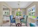 Bright dining area with a wooden table, colorful chairs, and view of a lush green yard at 16 Oakwood N Dr # 16, Englewood, FL 34223