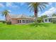 Exterior home showcasing lush landscaping, including mature palm trees and a vibrant green lawn at 16 Oakwood N Dr # 16, Englewood, FL 34223