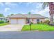 Inviting home featuring a well-maintained lawn, two-car garage, and appealing facade at 16 Oakwood N Dr # 16, Englewood, FL 34223