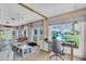 Comfortable sunroom featuring neutral tones, large windows offering outdoor views, and functional workspace at 16 Oakwood N Dr # 16, Englewood, FL 34223