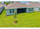A well-maintained backyard with lush green grass and a view of the home's screened-in patio at 1607 Laurel Brook Ln, Port Charlotte, FL 33953