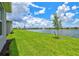 Lush green backyard extends to a tranquil lake with a fountain in a serene setting at 1607 Laurel Brook Ln, Port Charlotte, FL 33953