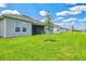 View of the side and backyard and patio area featuring green lawn and trimmed bushes and trees at 1607 Laurel Brook Ln, Port Charlotte, FL 33953