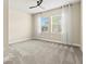 Light-filled bedroom with a ceiling fan, gray carpeting, and two bright windows at 1607 Laurel Brook Ln, Port Charlotte, FL 33953