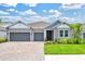 Charming single-story home featuring a three-car garage, lush landscaping, and a welcoming entrance at 1607 Laurel Brook Ln, Port Charlotte, FL 33953