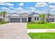 Charming single-story home featuring a three-car garage, lush landscaping, and a welcoming entrance at 1607 Laurel Brook Ln, Port Charlotte, FL 33953