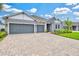 Charming single-story home featuring a three-car garage, lush landscaping, and a welcoming entrance at 1607 Laurel Brook Ln, Port Charlotte, FL 33953