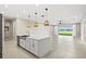 Open-concept kitchen featuring a large island, modern lighting, and an adjacent dining area with water view at 1607 Laurel Brook Ln, Port Charlotte, FL 33953