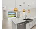 Open kitchen with pendant lighting and an island, overlooking a backyard lake view at 1607 Laurel Brook Ln, Port Charlotte, FL 33953
