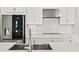 Bright, white kitchen featuring stainless steel appliances, white cabinets, and stylish backsplash at 1607 Laurel Brook Ln, Port Charlotte, FL 33953