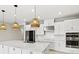 Modern kitchen with a large island, stainless steel appliances, and unique pendant lighting at 1607 Laurel Brook Ln, Port Charlotte, FL 33953