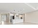 Bright, open kitchen with white cabinetry, large island with pendant lighting, and stainless steel appliances at 1607 Laurel Brook Ln, Port Charlotte, FL 33953