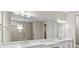 An interior view of the main bathroom featuring double sinks, large mirrors, and a glass enclosed shower at 1607 Laurel Brook Ln, Port Charlotte, FL 33953