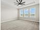 Spacious main bedroom with carpet, a ceiling fan, and three large windows overlooking a water view at 1607 Laurel Brook Ln, Port Charlotte, FL 33953