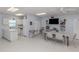 Spacious community room with a kitchen, dining tables, seating area, and a television at 168 The Corso # 168, Venice, FL 34285