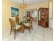 Bright dining area with a glass-top table, stylish rattan chairs and a view of the living room at 168 The Corso # 168, Venice, FL 34285