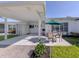 Exterior of home featuring a covered patio with outdoor seating and manicured lawn at 168 The Corso # 168, Venice, FL 34285