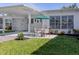 Charming home featuring a covered patio with seating and a manicured lawn at 168 The Corso # 168, Venice, FL 34285
