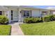 Charming single-story home featuring a well-maintained lawn, walkway and quaint front door at 168 The Corso # 168, Venice, FL 34285