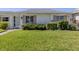 Charming villa with a lush green lawn and inviting curb appeal, featuring pink shuttered windows at 168 The Corso # 168, Venice, FL 34285
