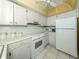Efficient kitchen featuring white cabinets, essential appliances, and ample counter space at 168 The Corso # 168, Venice, FL 34285
