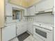 Well-lit kitchen featuring white cabinets, essential appliances, and plenty of counter space at 168 The Corso # 168, Venice, FL 34285