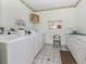 Clean community laundry room with multiple washers, dryers, and ample counter space at 168 The Corso # 168, Venice, FL 34285