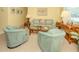Comfortable living room with neutral carpet, matching furniture, and a charming tropical aesthetic at 168 The Corso # 168, Venice, FL 34285