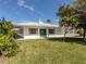 Charming pool house with a green door, light exterior and surrounded by lush landscaping at 168 The Corso # 168, Venice, FL 34285