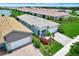 Aerial view of a modern home showcasing a manicured yard, stone driveway, and proximity to the neighborhood lake at 17873 Grand Prosperity Dr, Venice, FL 34293