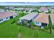 Wide aerial shot of residential community with houses featuring well-manicured lawns, landscaping, and pond views at 17873 Grand Prosperity Dr, Venice, FL 34293