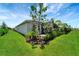 Home exterior showcasing a landscaped backyard with lush green grass and mature trees at 17873 Grand Prosperity Dr, Venice, FL 34293