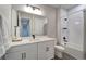 Modern bathroom with white cabinetry, a large mirror, and a tub-shower combo at 17873 Grand Prosperity Dr, Venice, FL 34293
