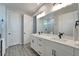 This is a spacious bathroom with double sinks, white cabinets, and wood-look tile floors at 17873 Grand Prosperity Dr, Venice, FL 34293
