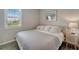 Well-lit bedroom featuring a large window, comfortable bed, and stylish nightstand at 17873 Grand Prosperity Dr, Venice, FL 34293